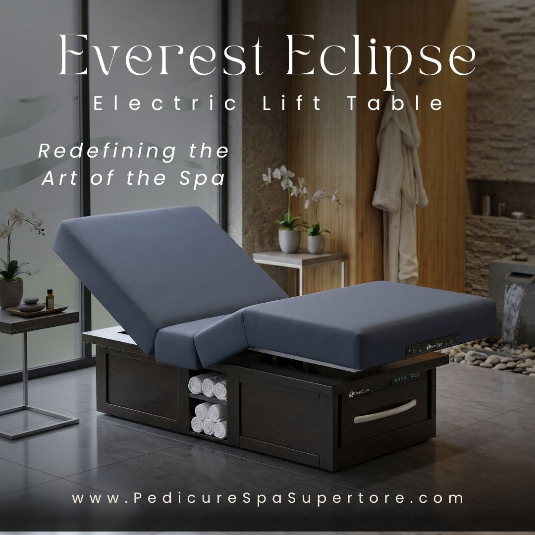 Motorized electric lift massage table with foot pedal controller and plush gray cushioning.