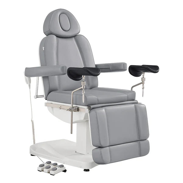 Professional Gray electric medical and spa procedure chair with adjustable armrests, leg rests, and a foot remote control, isolated on a white background.