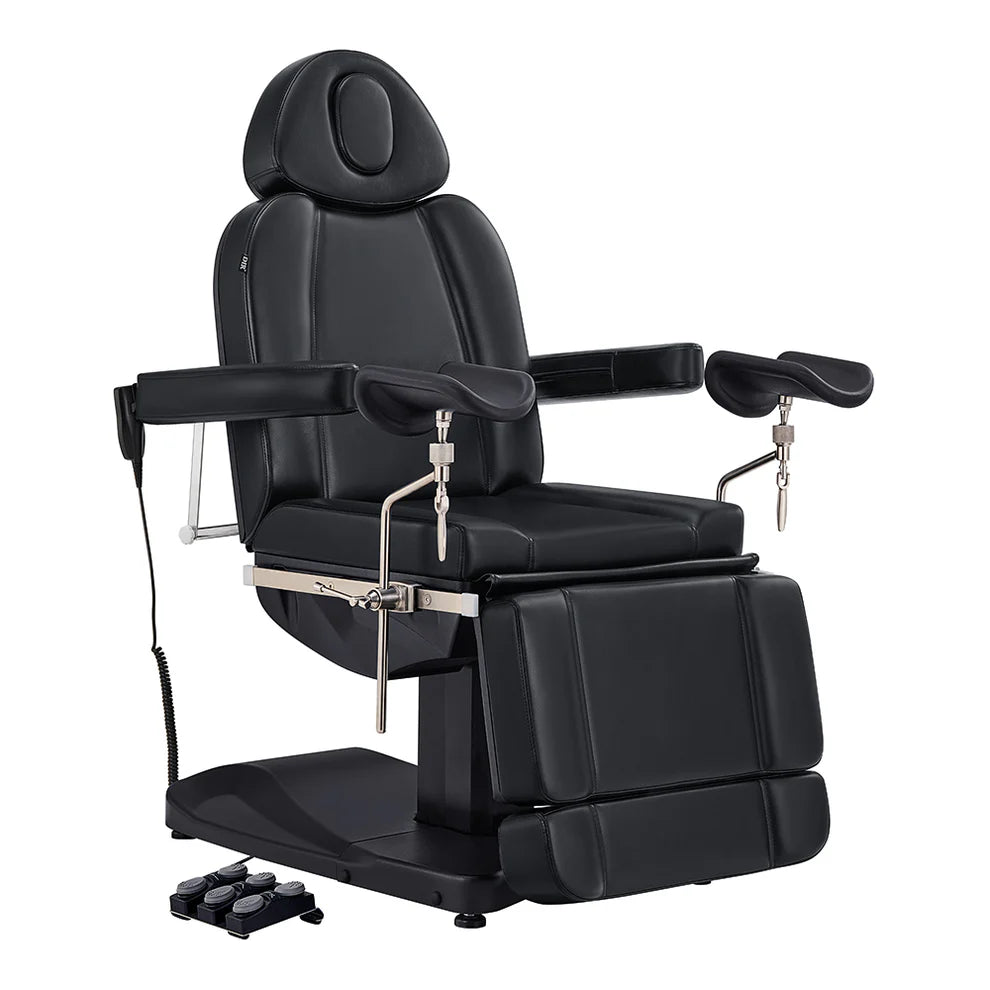 Professional black electric medical and spa procedure chair with adjustable armrests, leg rests, and a foot remote control, isolated on a white background.
