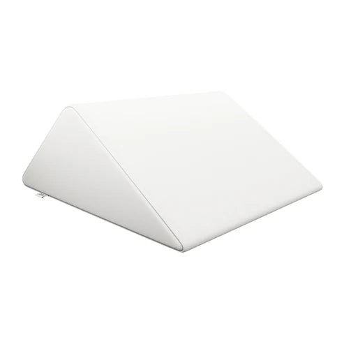 DIR White triangular foam bolster pillow providing leg and back support on a massage bed.